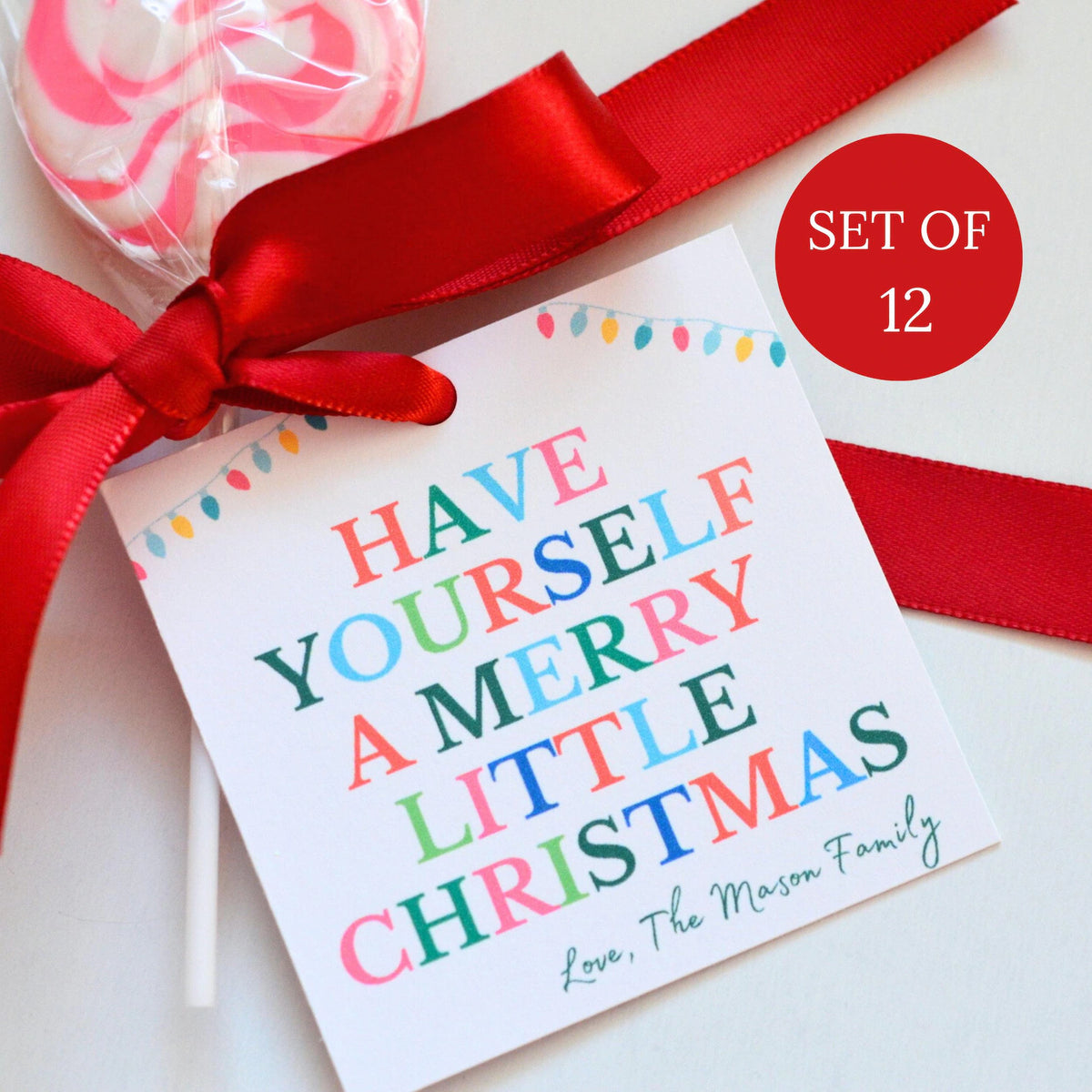 A set of personalized Christmas lollipop gift tags with a red ribbon and a pink and white lollipop, featuring the text 'HAVE YOURSELF A MERRY LITTLE CHRISTMAS' and 'Love, The Mason Family'. A red circular badge reads 'SET OF 12'.