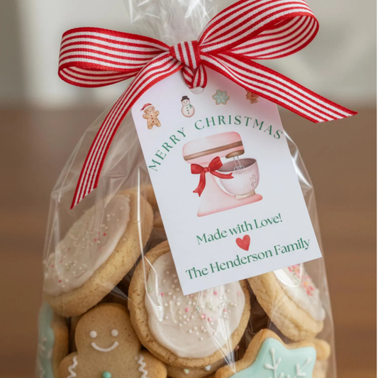 A clear cellophane gift bag filled with assorted decorated Christmas cookies, tied with a red-and-white striped ribbon and a printed tag that reads 'Merry Christmas Made with Love! The Henderson Family.'.