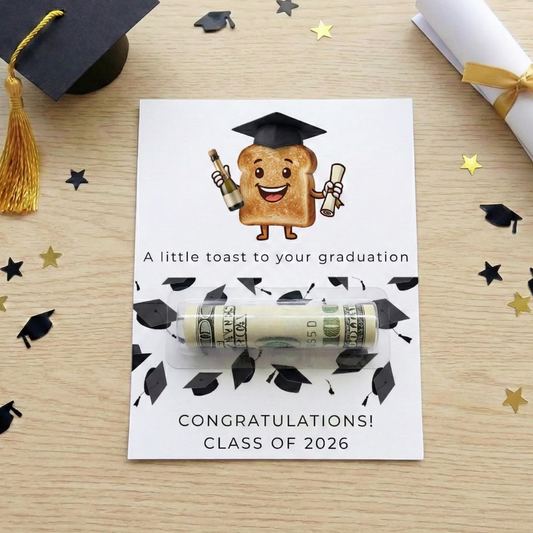 A graduation-themed card featuring a cartoon toast character wearing a black graduation cap and holding a diploma and bottle. The card reads 'A little toast to your graduation' and 'CONGRATULATIONS! CLASS OF 2026'.