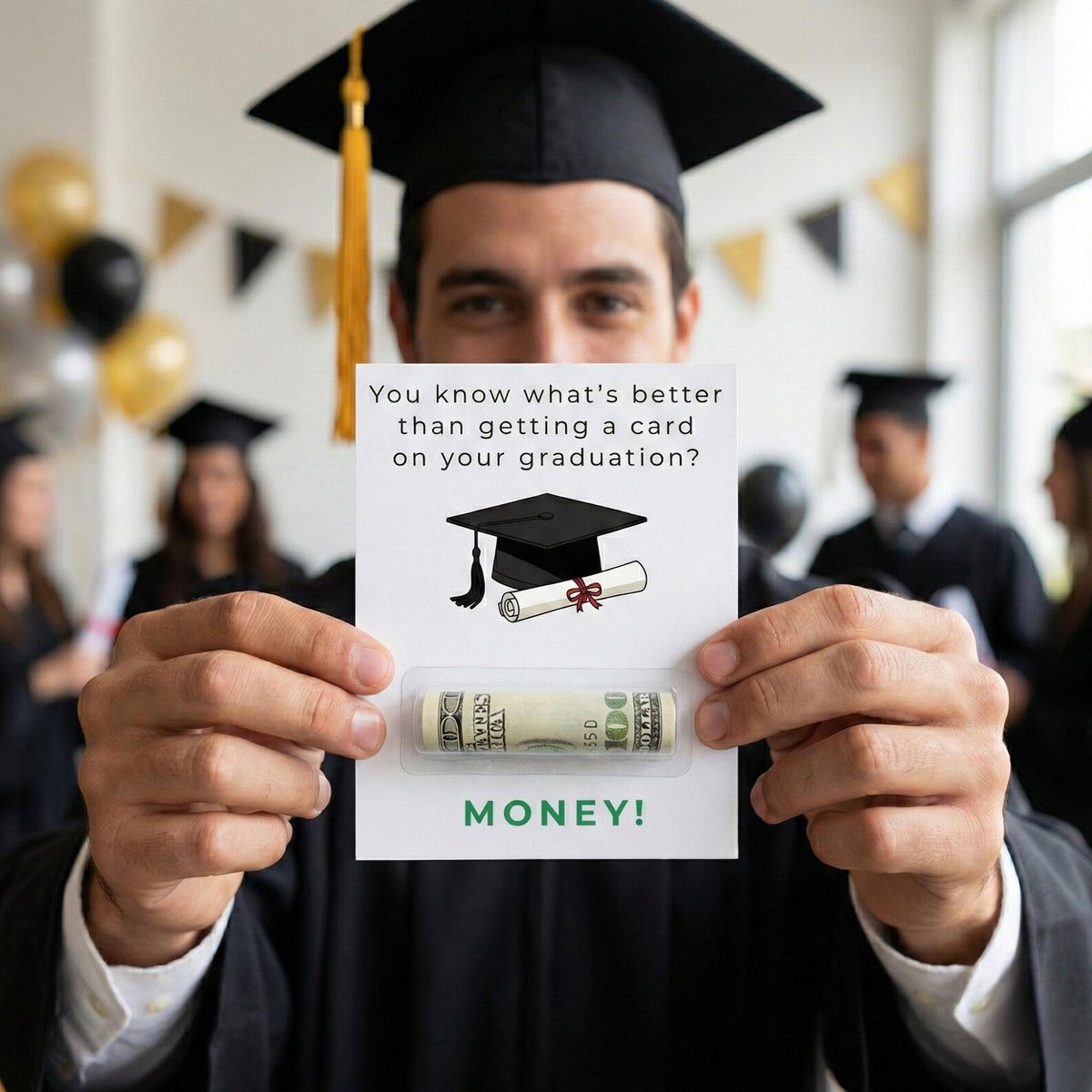 A graduate in a black cap and gown holds up a novelty card that says 'You know what's better than getting a card on your graduation?' with an illustration of a graduation cap and a rolled dollar bill, plus the word 'MONEY!' at the bottom.