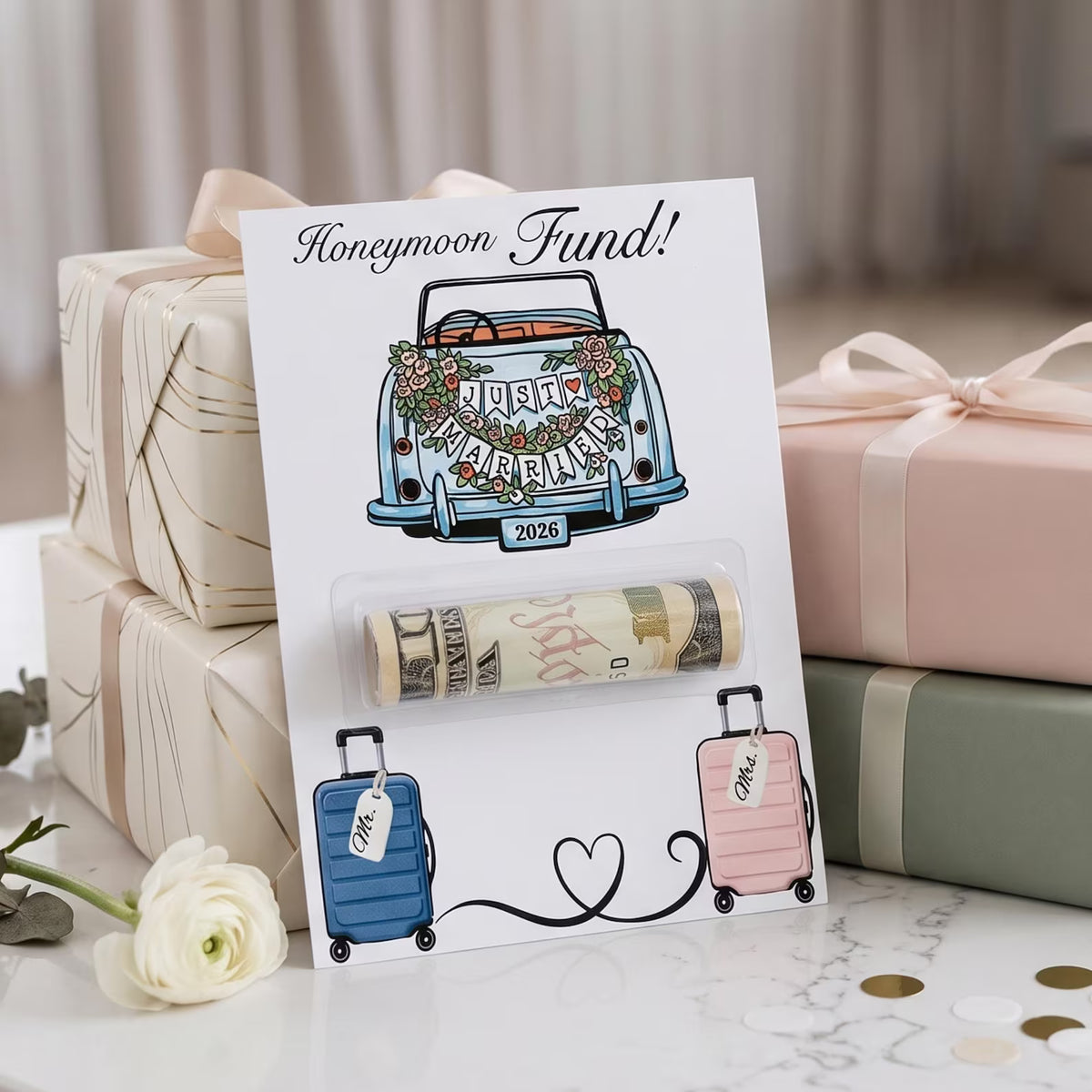 Honeymoon Fund money holder card on display in front of several other wrapped presents on a white marble table. 